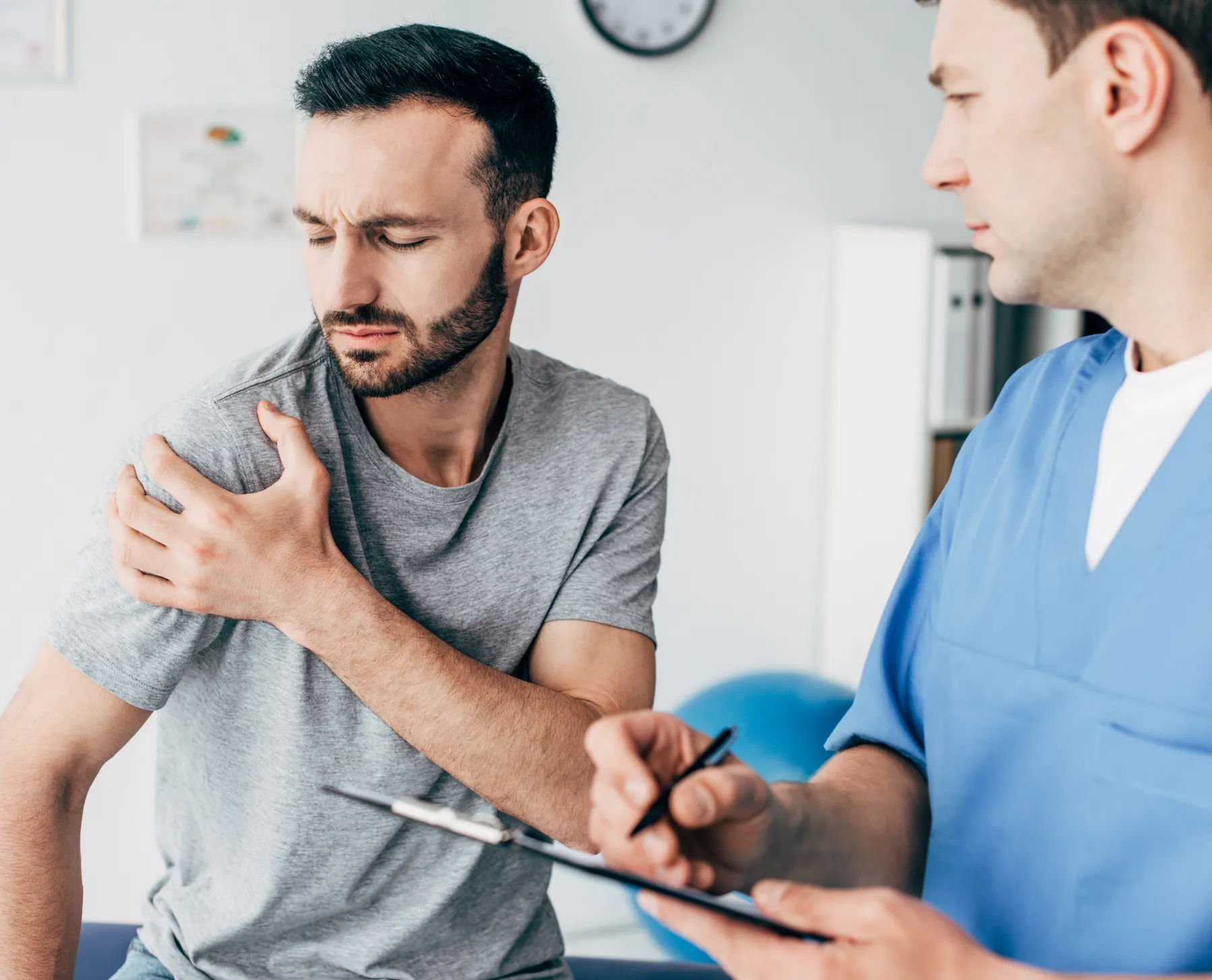 Shoulder pain physical therapy. Patient consults with therapist for rehab treatment. Pain relief and mobility recovery.