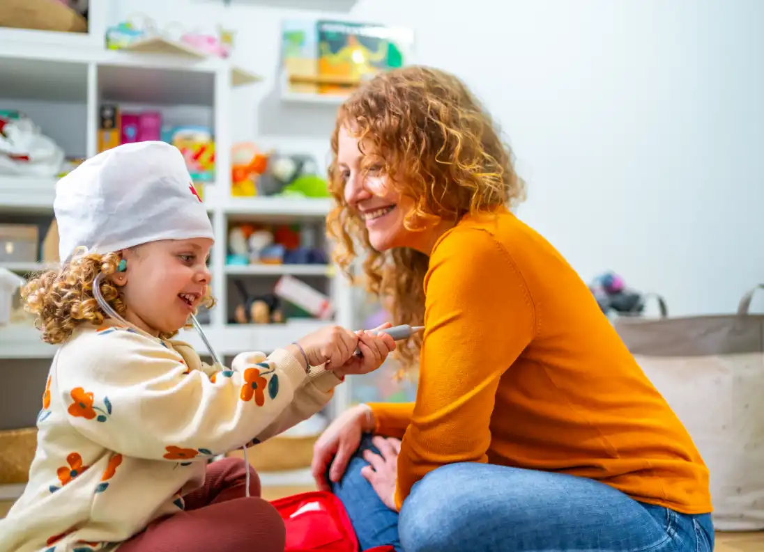 Pediatric therapy session: Child playing doctor, gaining confidence and joy. Physical therapy for improved mobility.
