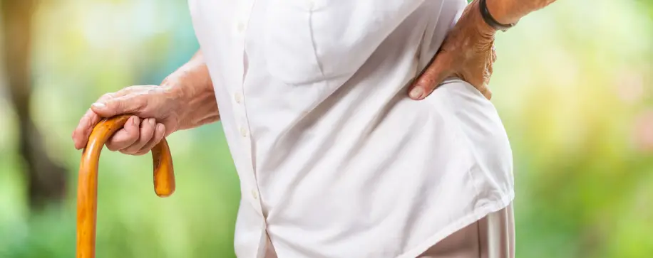 Hip bursitis pain relief. Hands on hips. Physical therapy for mobility recovery. Work injury rehab at rehabilitation clinic.